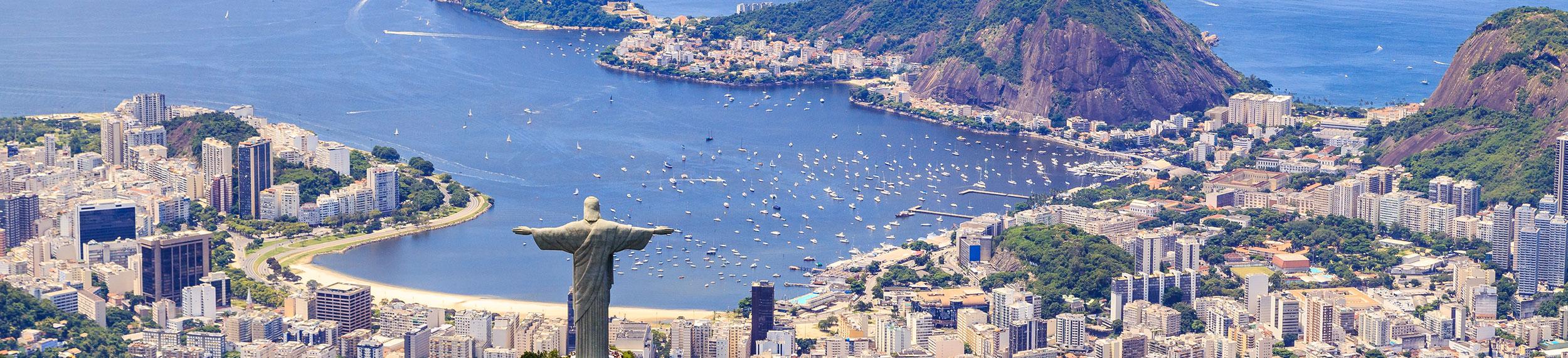 Aerial view of Christ The Redeemer Monument on Corcovado Mountain overlooking the water on a sunny day in Rio de Janeiro, Brazil.