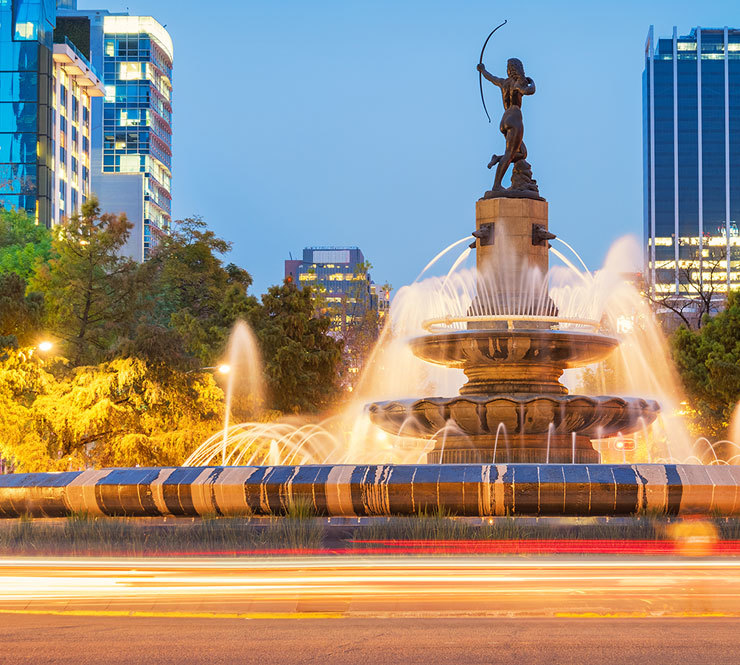 The Diana the Huntress Fountain on Paseo de la Reforma Avenue with a view of downtown Mexico City in the background. 
