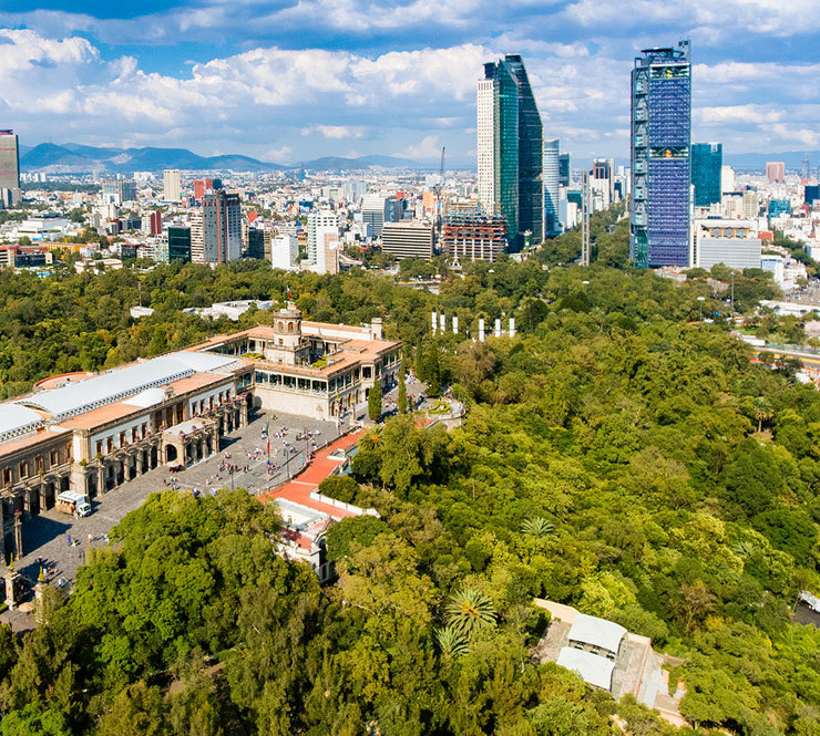 Aerial view of Mexico City skyline and lush green trees around Chapultepec Castle from Chapultepec Park in Mexico. 