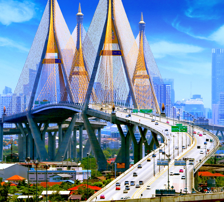 international-Bhumibol Bridge with traffic and blue buildings in the background in Bangkok, Thailand.