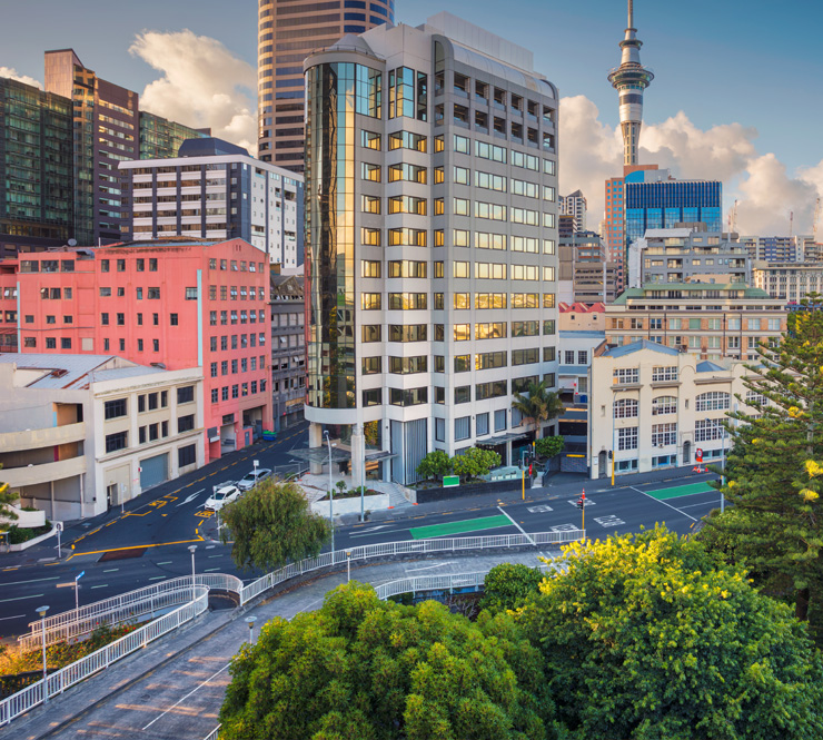 Aerial cityscape image of downtown buildings and Sky Tower in Auckland, New Zealand.