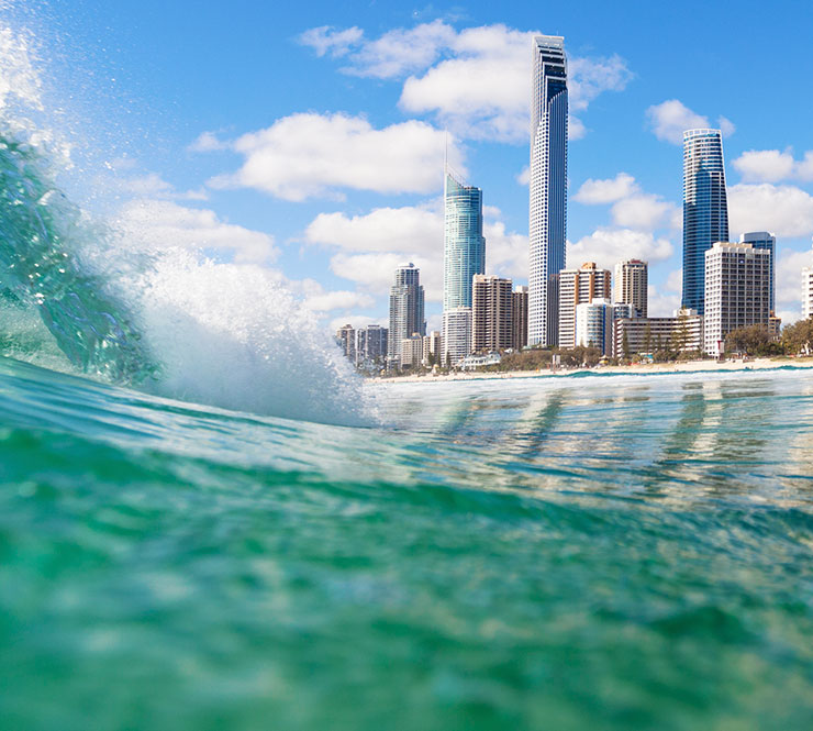 Aqua colored waves and skyline at Surfers Paradise Beach in Queensland, Australia.