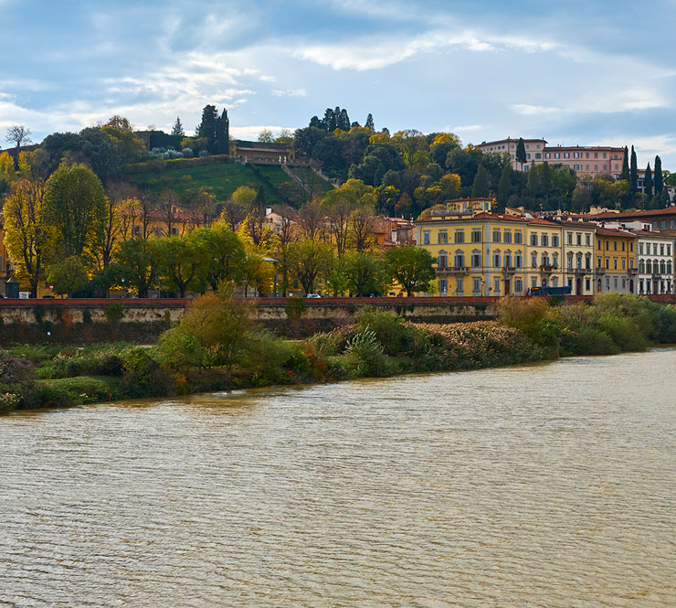 Colorful stucco villas, palazzo, stores and hotels overlooking the Arno River in Florence, Italy.