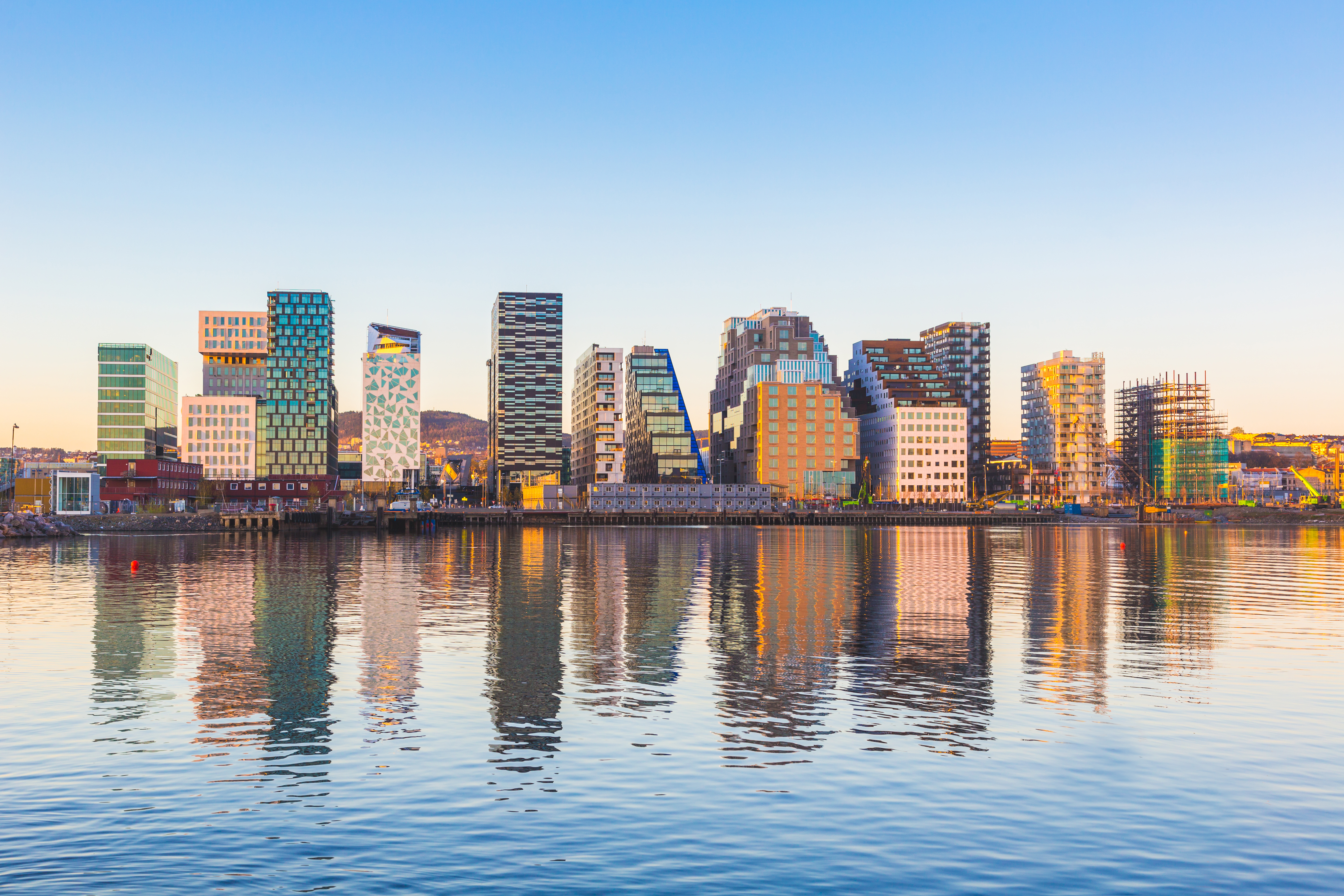View of modern Oslo buildings, reflecting off the water at sunrise.