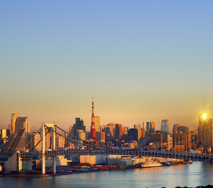 A view of the Tokyo cityscape over Tokyo Bay at sunrise. 