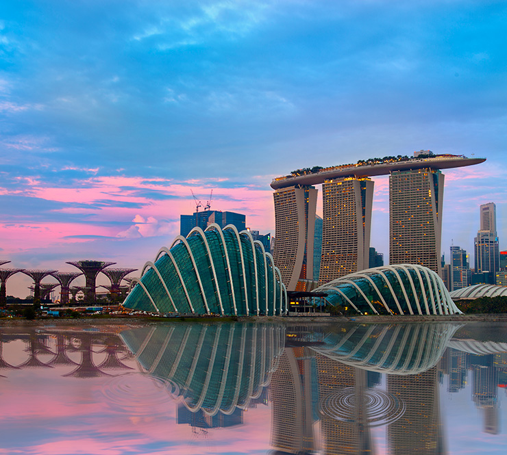 A blue and pink sky serves as a background to Singapore's skyscrapers and modern architecture on Marina Bay.