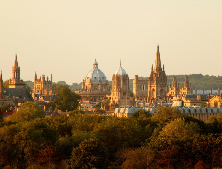 Castles and traditional buildings in the Oxford, UK skyline at sunset.