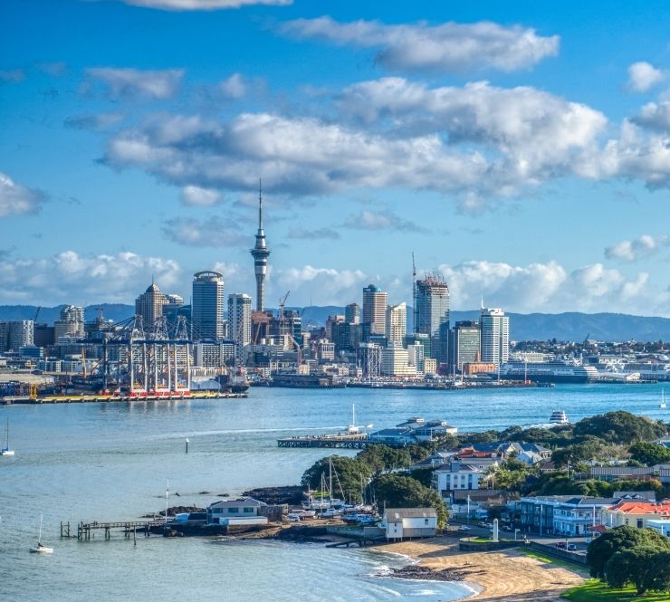 Aerial cityscape image of downtown buildings and Sky Tower in Auckland, New Zealand.