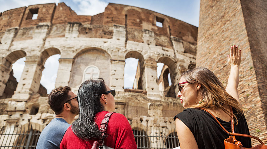 Female teacher points out details of some Roman ruins.