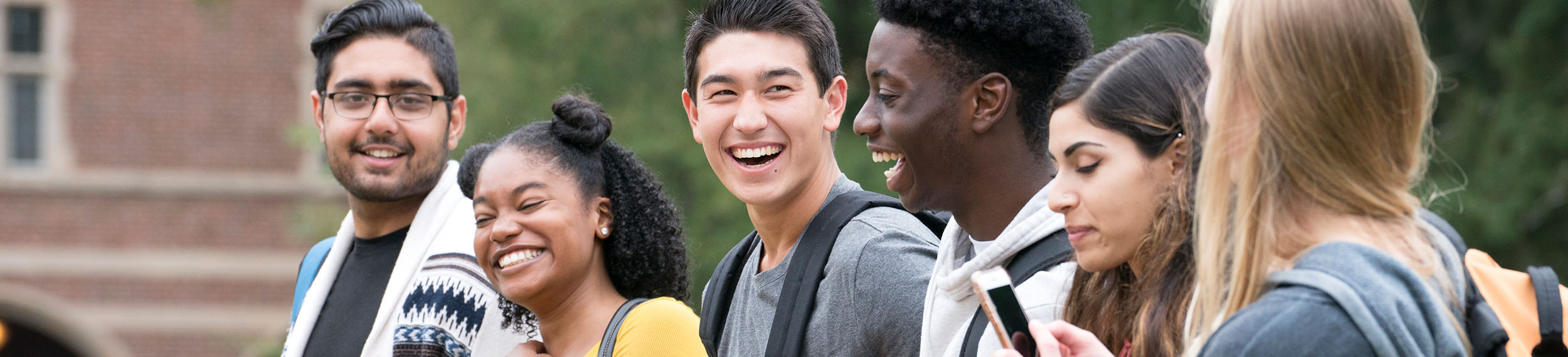 A group of students laughing together on campus. 
