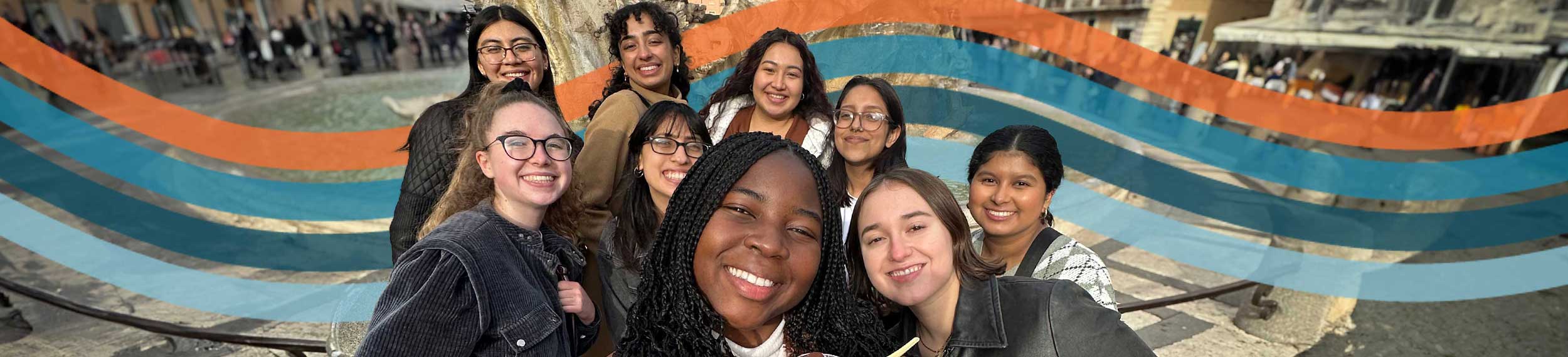 Group of students in front of ornate stone fountain in an Italian town square.