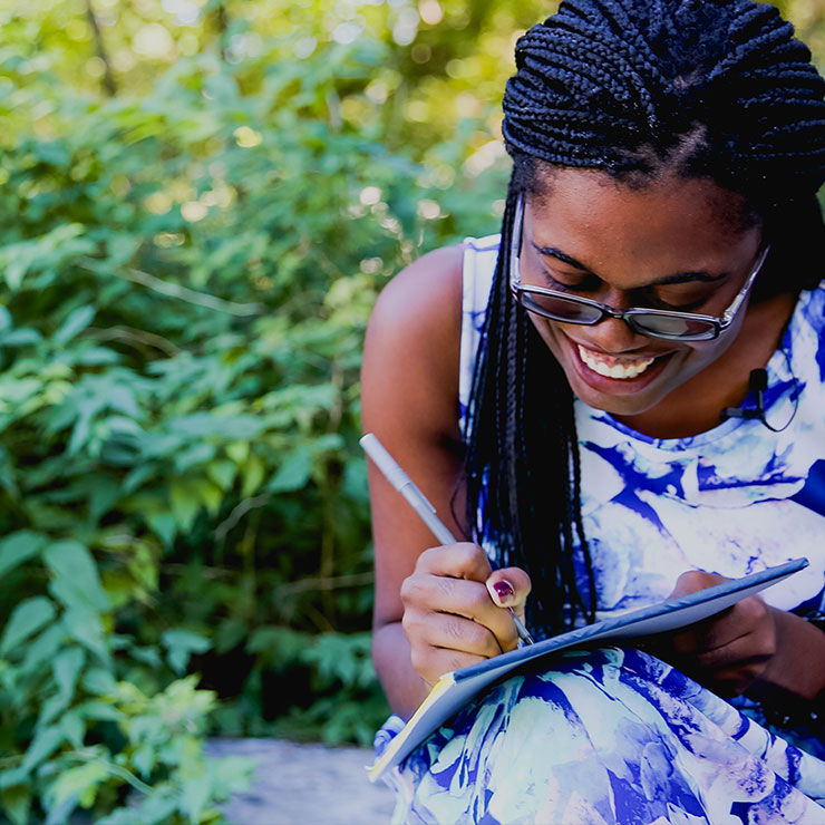 A woman writes on a notepad.