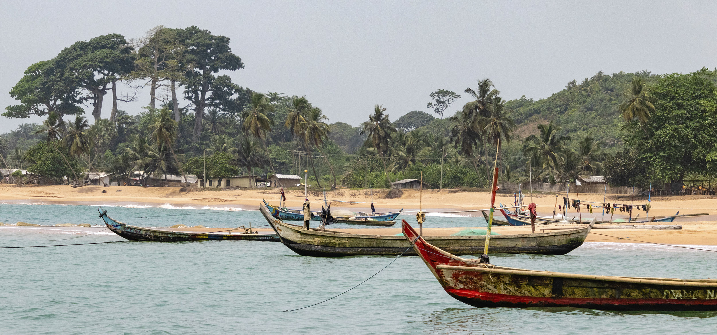 Fishing boats on the water near a beach in Axim, Ghana. 