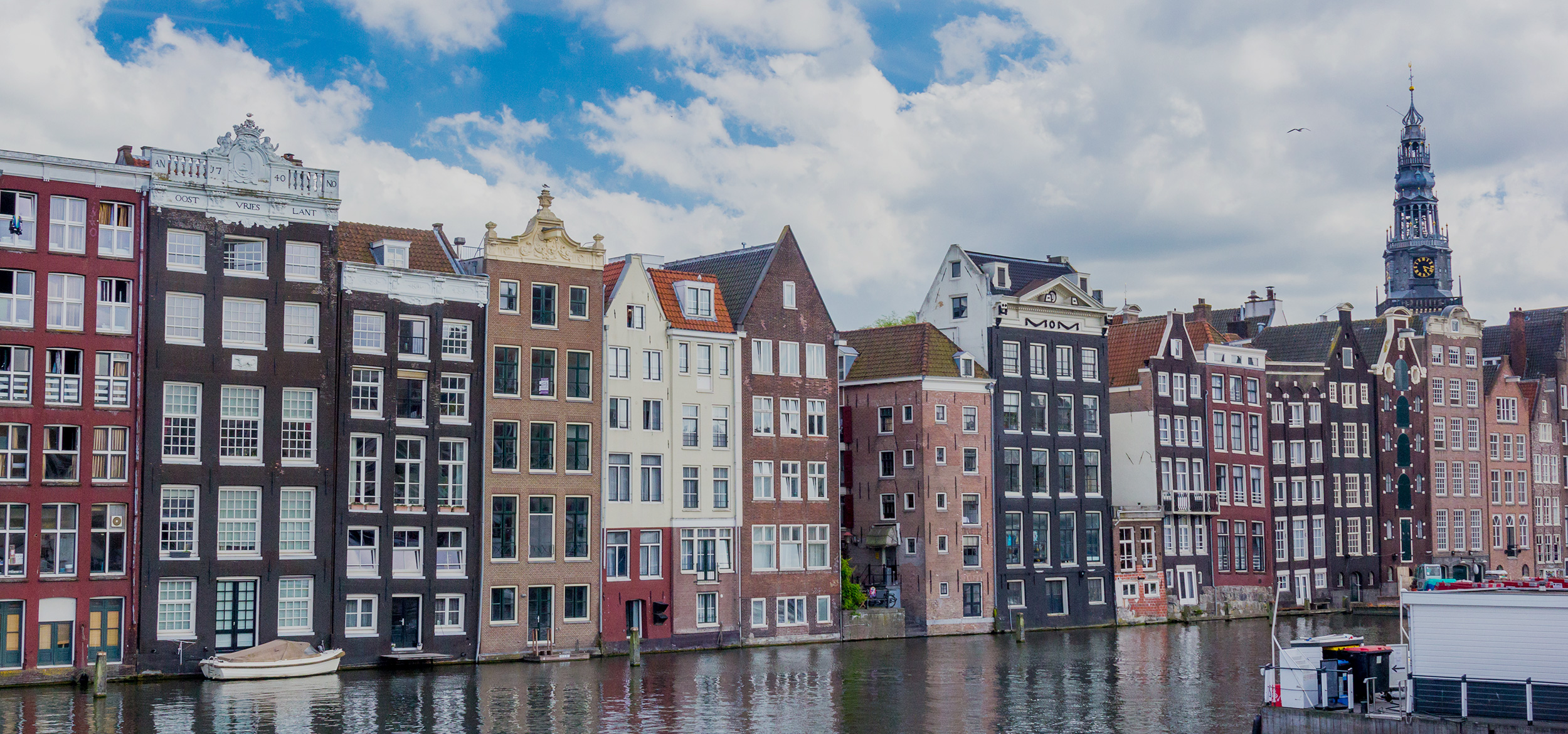 Colorful row of old Dutch houses reflected in a canal in Amsterdam in the Netherlands.