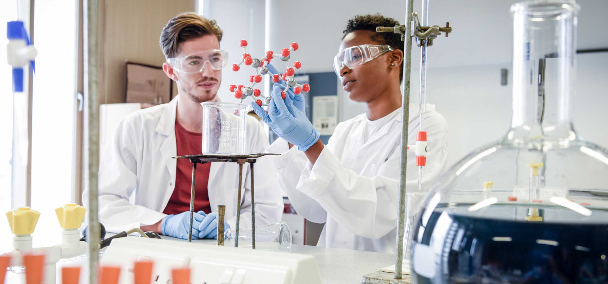 Students working in a lab with a model of a molecular structure.