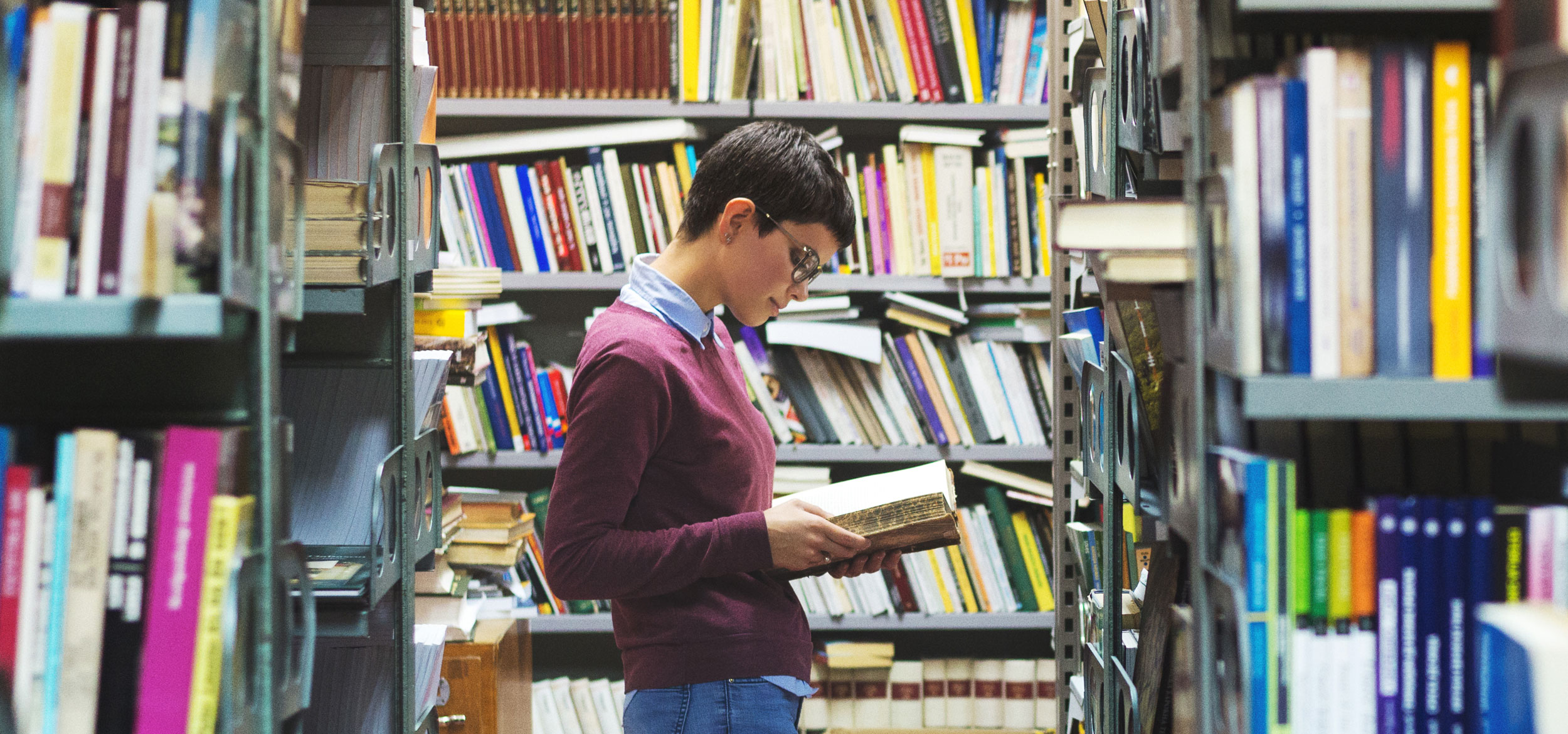 A female student reads a philosophy book in the library.