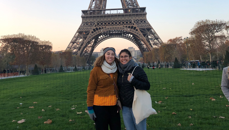 Two students standing in front of the Eiffel Tower in Paris France.