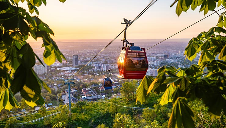 Kok Töbe cable car ride over Almaty city at sunset