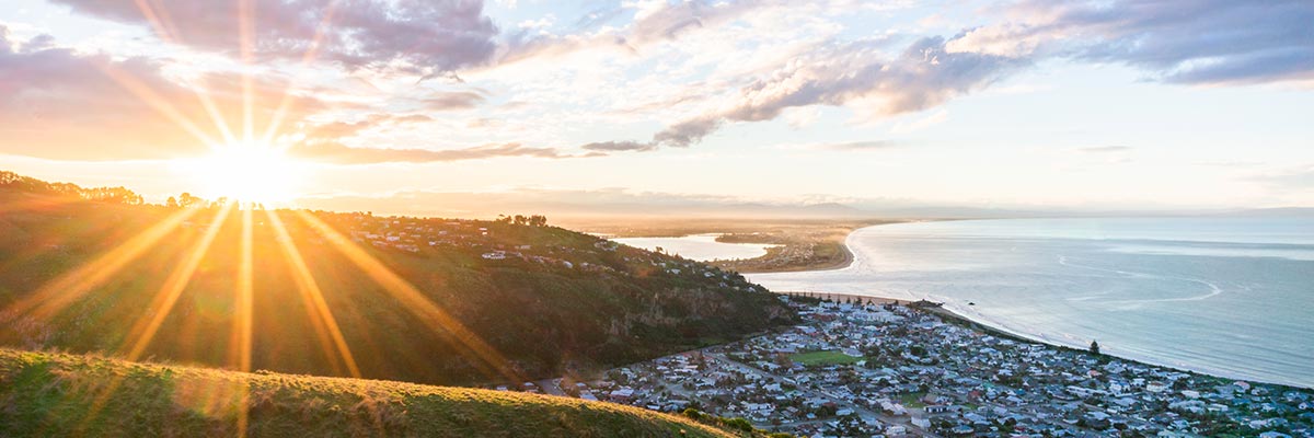 Sunset and scenic view of ocean and Sumner beach town, Christchurch, New Zealand.
