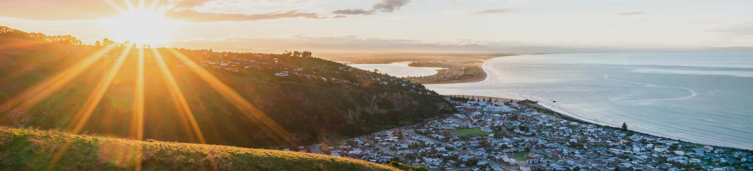 Sunset and scenic view of ocean and Sumner beach town, Christchurch, New Zealand.