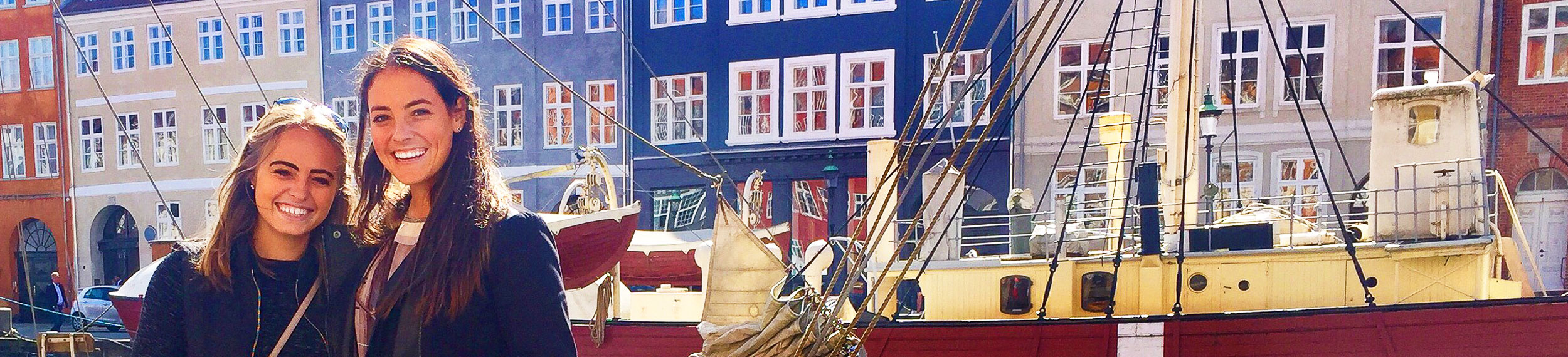 Two UCEAP students near Nyhavn canal with colorful buildings in the background. 