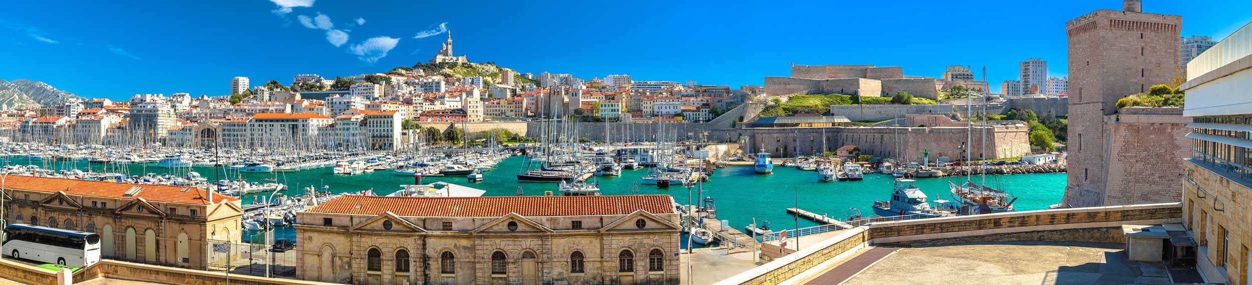  View of City of Marseille harbor and Notre Dame de la Garde church on the hill above the water.