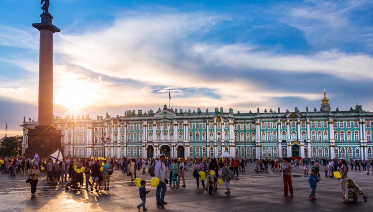 People enjoying the sunset on Navy day at Palace square with the Hermitage, the Winter Palace and Alexander Column in Saint Petersburg, Russia.