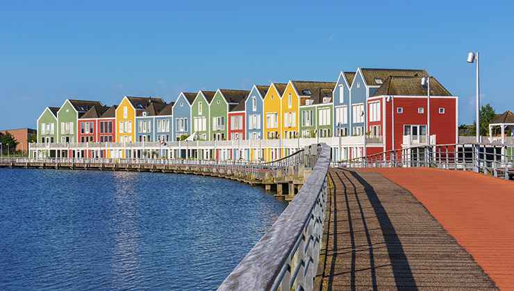 A row of modern multi-colored houses by the water in the Utrecht region.