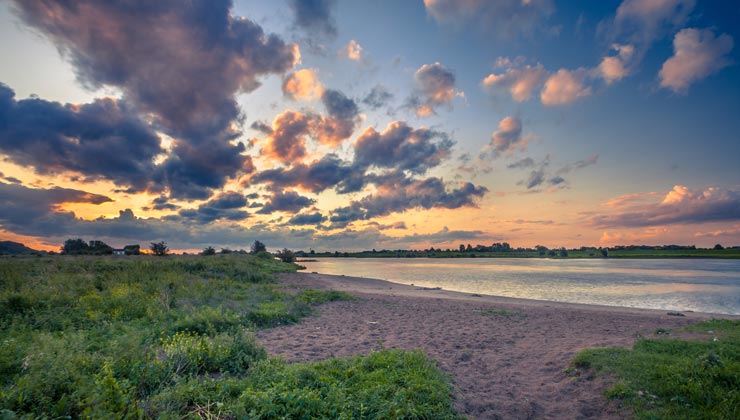 View of Wageningen Beach next to the Rhine River at sunset. 