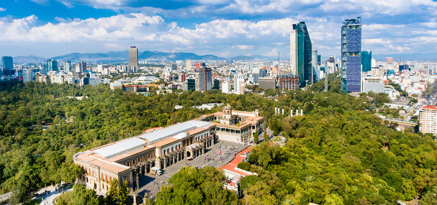 Aerial view of Mexico City skyline and lush green trees around Chapultepec Castle from Chapultepec Park in Mexico. 