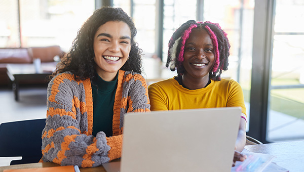 two people working on laptop smiling