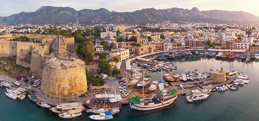 Aerial View of Old Marina in Girne (Kyrenia), Cyprus with mountains in background.