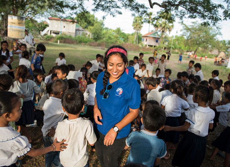 A Peace Corps participant volunteers with children while on a program. 