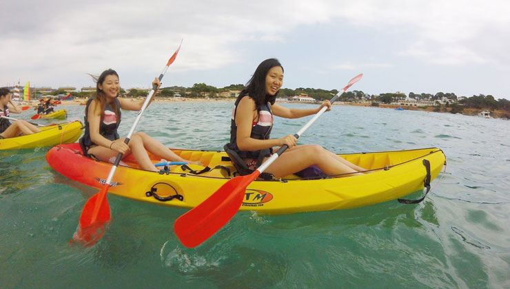 Two female students paddle boating in Brava, Spain.