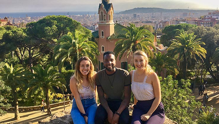 Three students smiling at Park Güell in Barcelona, Spain.