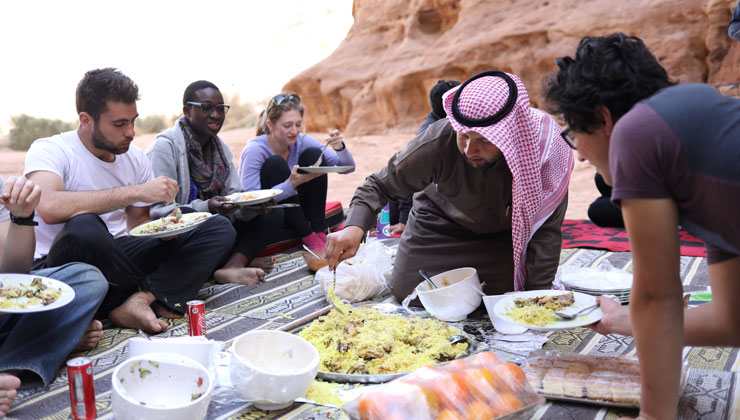 UCEAP students eating together on a patterned blanket in Amman, Jordan. 