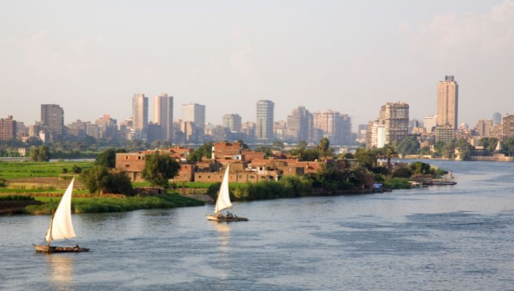 A view of the Nile River from Cairo bridgeway with two feluka boats sailing on the water.