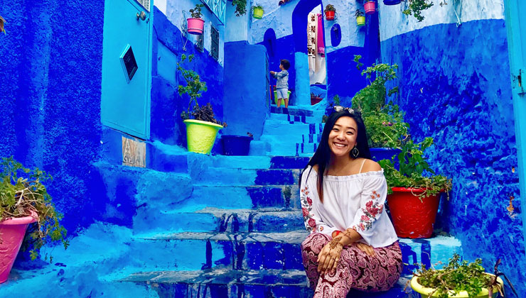 UCEAP student sitting on bright blue steps in Chefchaouen, Morocco. 