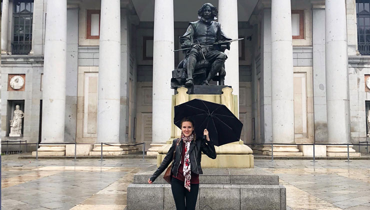 Female student with umbrella in the rain at Museo Nacional del Prado in Madrid, Spain