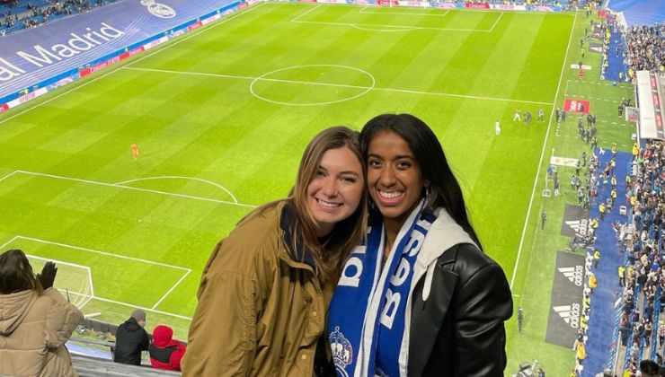 Two students smile in the stands of a football stadium in Madrid, Spain.