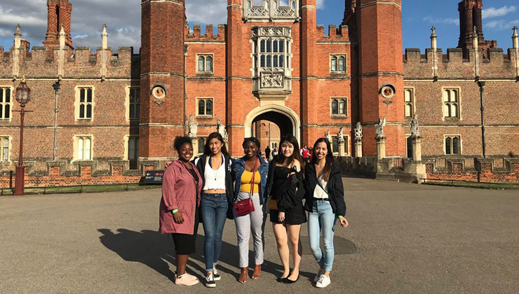 Four students standing in front of Kensington Palace in England.