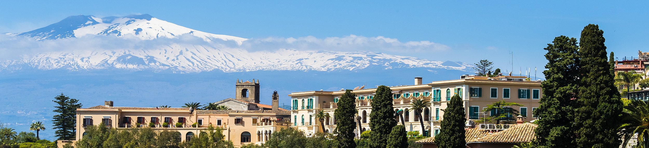 View of a hotel in Taormina, Sicily in Mount Etna in the background.