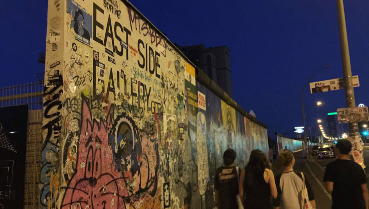 Group of students walk along the East Side Gallery in Berlin, Germany.