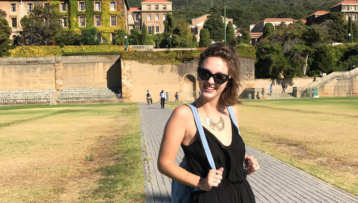 A student smiling on the University of Cape Town campus in Cape Town, South Africa. 