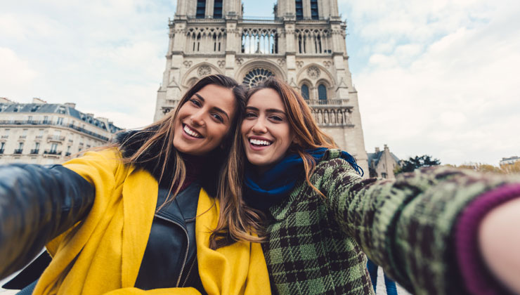 Two female student posing in front of the Notre Dame Cathedral in Paris, France.