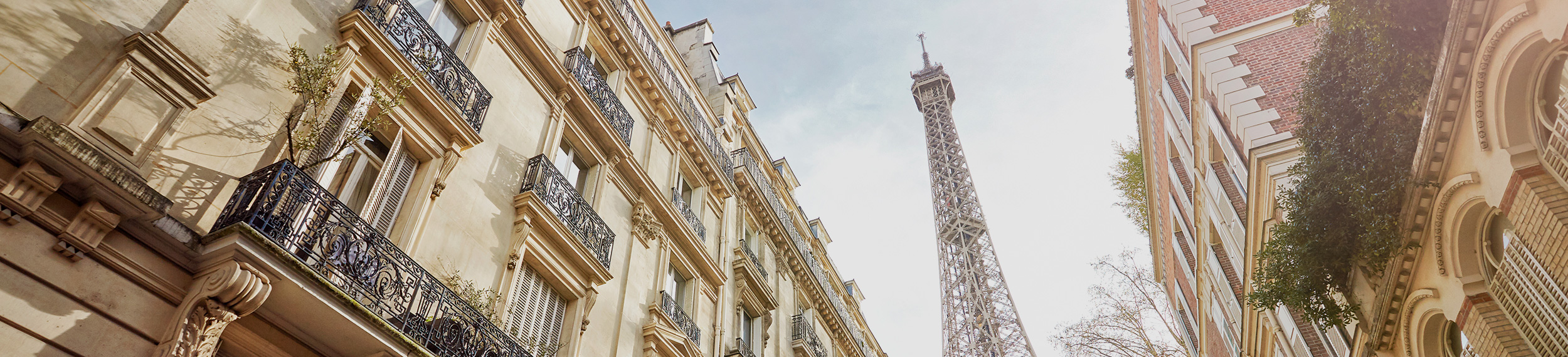 Looking up at The Eiffel Tower through Paris housing.