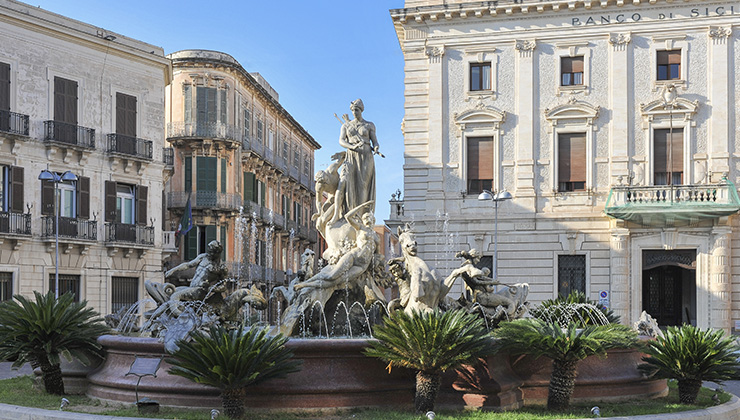 The ornate sculptures of the Fountain of Artemis mark the city center on the island of Ortigia.