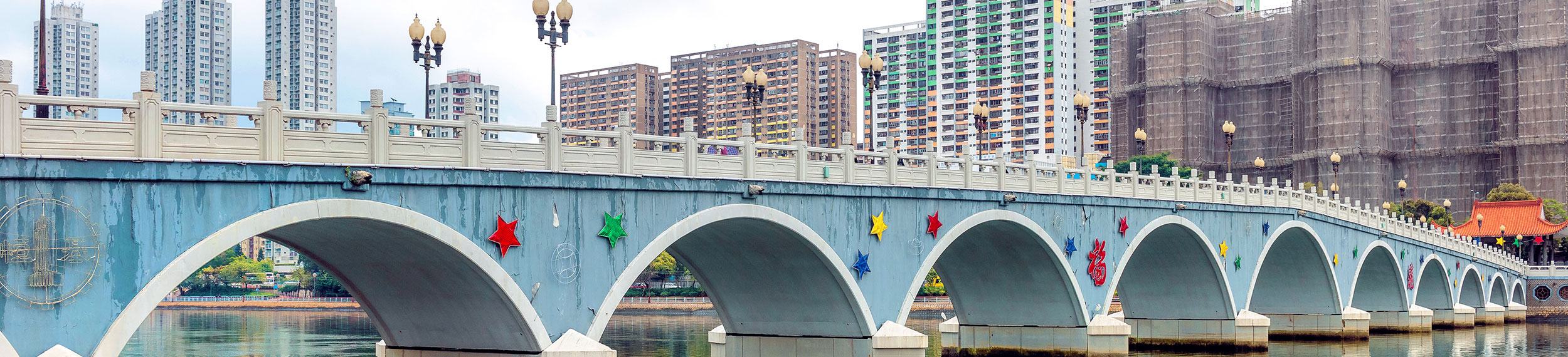 Colorful bridge with residential district of Sha Tin, Hong Kong in the background.