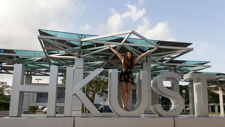 Student stands in the U of the HKUST artwork at the Hong Kong University of Science and Technology.