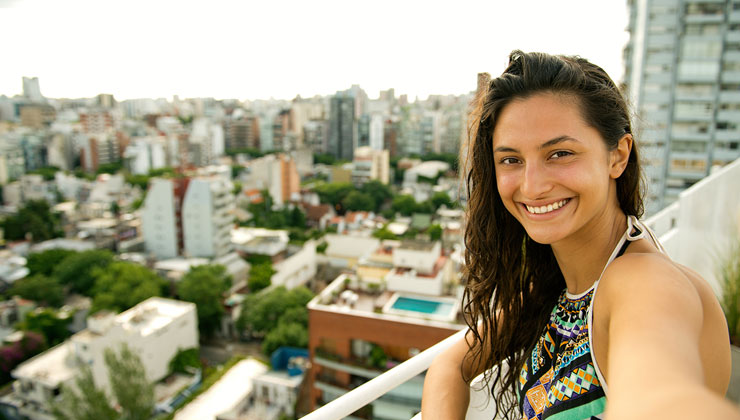 Woman smiles and takes a selfie on a sunny day in Buenos Aires, Argentina.